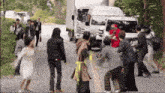 a group of people are standing on the side of a road in front of a white truck that says tv asahi on it
