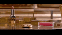a close up of lipstick and lip gloss on a mirror