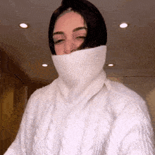 a woman wearing a white sweater with a high turtleneck