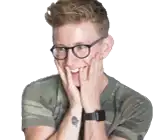 a man with glasses and a tattoo on his wrist is smiling .