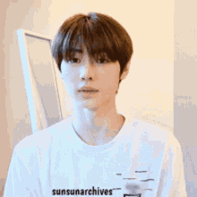 a young man wearing a white shirt with the words sunsunarchives on it