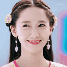 a close up of a woman 's face with a flower in her hair and earrings