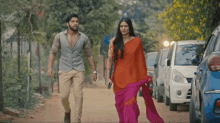 a man and a woman walking down a dirt road