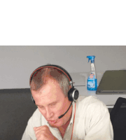a man wearing headphones sits in front of a spray bottle that says " cleaner " on it