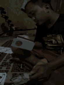 a man sitting on the floor looking at a card that says 2000 on it
