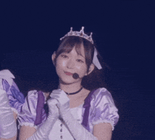 a woman in a purple dress and white gloves blowing a kiss