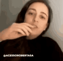 a woman is covering her mouth with her hand while talking on a cell phone .