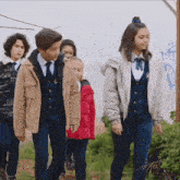 a group of children are walking in front of a white wall with graffiti on it that says ec2