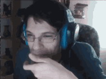 a man wearing headphones and glasses is pointing at something