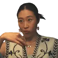 a woman wearing earrings and a necklace with the letter s on it