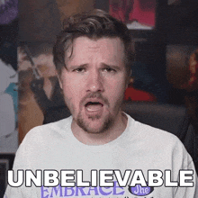 a man with a beard is wearing a white shirt that says " unbelievable "
