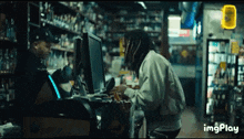 a man sitting at a counter in a store with a sign that says imgplay on it