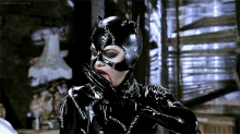 a woman in a catwoman costume with a bloody mouth