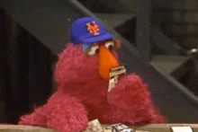 elmo from sesame street is wearing a new york mets baseball cap