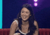 a woman is laughing while sitting on a couch .