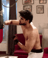 a shirtless man is hitting a punching bag that says everlast