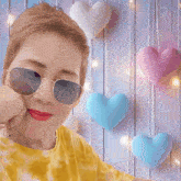 a woman wearing sunglasses is surrounded by glitter and stars