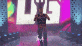 a man in a wrestling outfit is standing in front of a large screen that says jm4