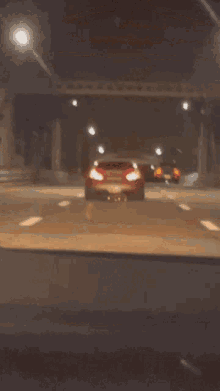 a blurred image of a car driving down a road at night