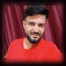 a man with a beard wears a red shirt and gold chain