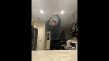 a man is standing in a kitchen with his arms up