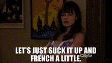 a woman is standing in front of a painting and says let 's just suck it up and french a little .