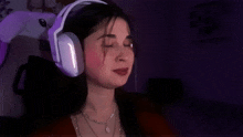 a woman wearing a pair of white headphones with purple lights on them