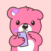 a pink teddy bear is holding a purple cellphone