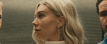 a close up of a woman 's face with a man standing behind her .