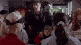 a man is standing in a crowd of people talking to a woman .