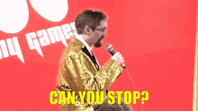 a man singing into a microphone with the words " can you stop " behind him