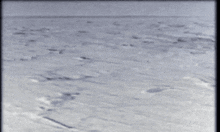 a black and white photo of a body of water with a few waves