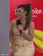 a woman holding a microphone in front of a sign that says television