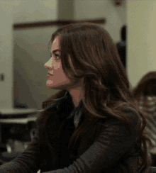 a woman with long brown hair is sitting at a table