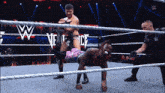 wrestlers in a wrestling ring with a w logo on the ropes