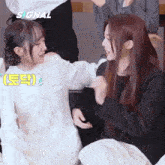 two girls are playing with each other with the word signal in the corner