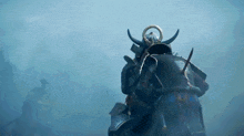 a samurai with horns and a helmet is walking through a foggy field