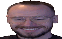 a man wearing glasses and a beard is smiling .