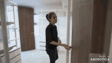 a woman opens a door with the words made in animatica below her