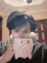 a person holding a piggy bank with a pig face on it