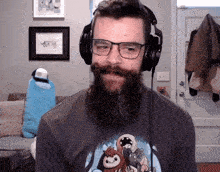 a man with a beard is wearing headphones and a t-shirt with sloths on it