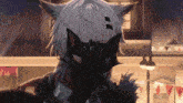 a person wearing a cat mask covering their face with their hands