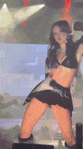 a woman is dancing on a stage with a microphone in her hand