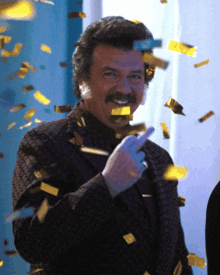 a man with a mustache is surrounded by golden confetti