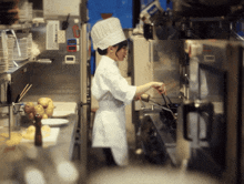 a woman in a chef 's hat is stirring a pot in a kitchen