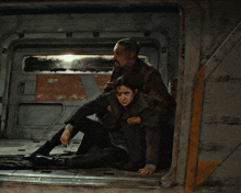 a man and a woman are sitting in a room