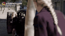 a woman getting out of a car with eltrecetv.com on the bottom right