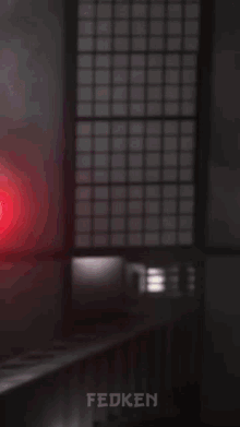 a red light is shining on a person 's head and the word fedken is below it