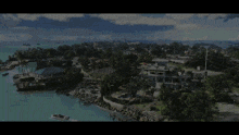 an aerial view of a tropical island with houses and boats