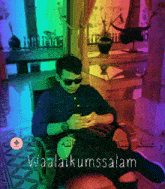 a man wearing sunglasses sits in a chair with the words waalaikumsalam written on the bottom